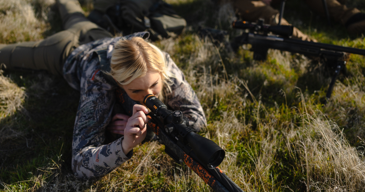 woman carrying rifle with horus scope with tremor9